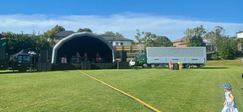 Inflatable stage cover set up on a sports field with the event truck alongside