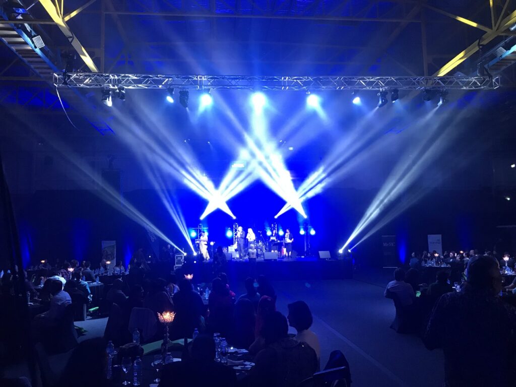 Moving-head stage lighting and truss at an indoor concert in Auckland